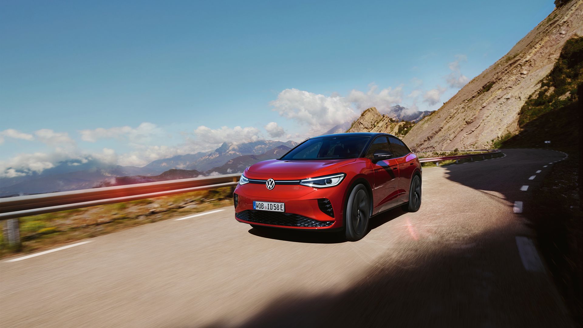 Rdeči VW ID.5 GTX se dinamično pelje po gorski cesti. Pogled na masko, kolesa in od strani.