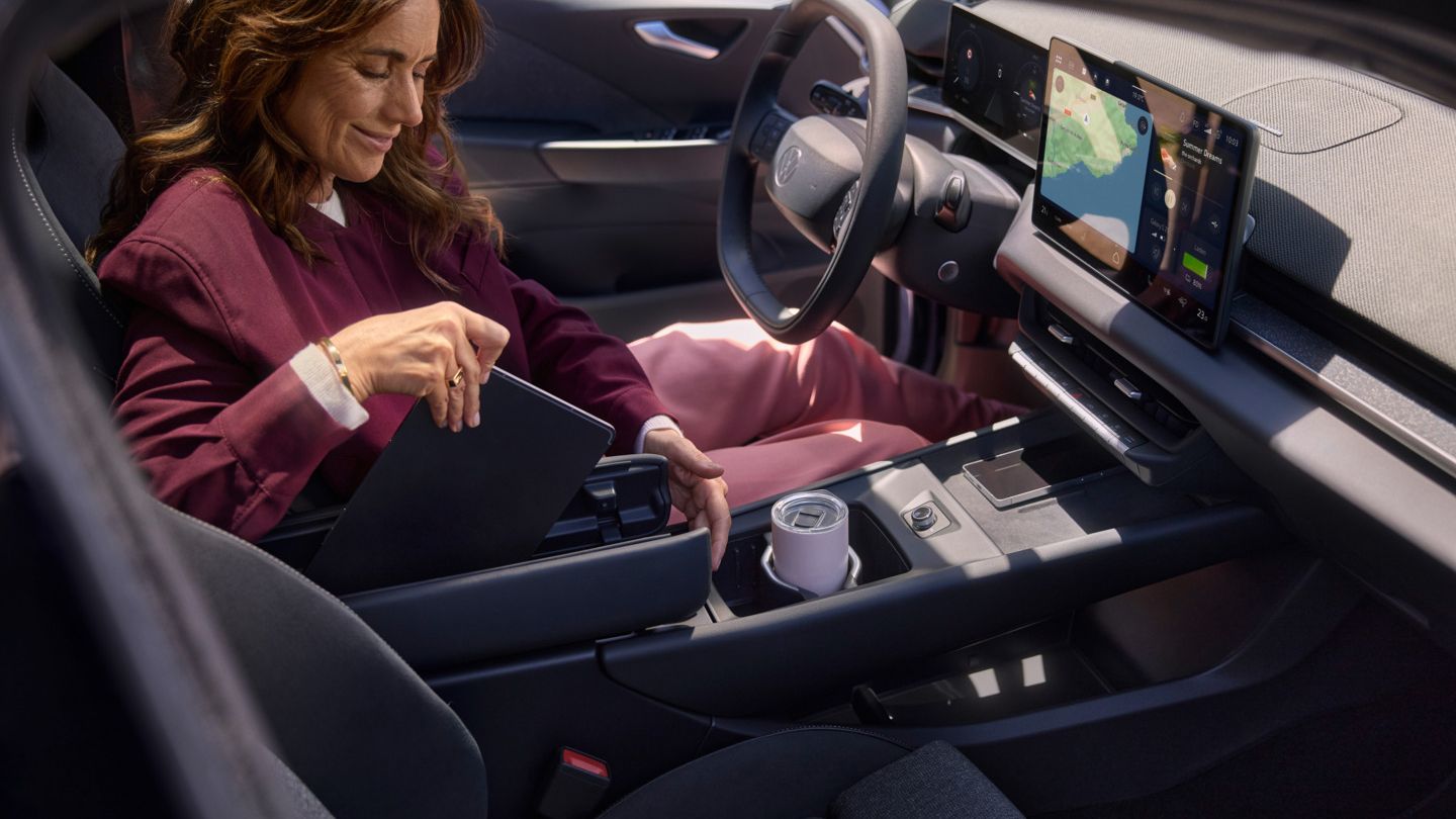 Ženska pospravi tablico v VW ID.3 Neo v sredinski konzoli z metuljastim naslonom za roke