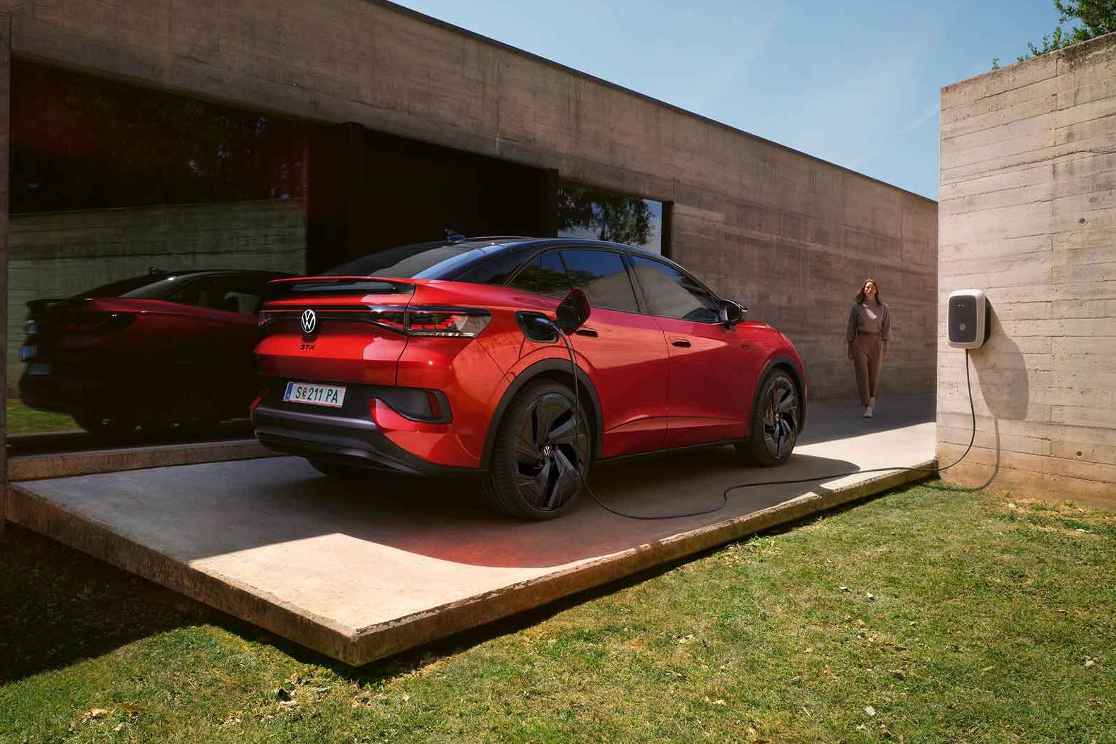 Roter VW ID.5 GTX wird vor Gebäude geladen