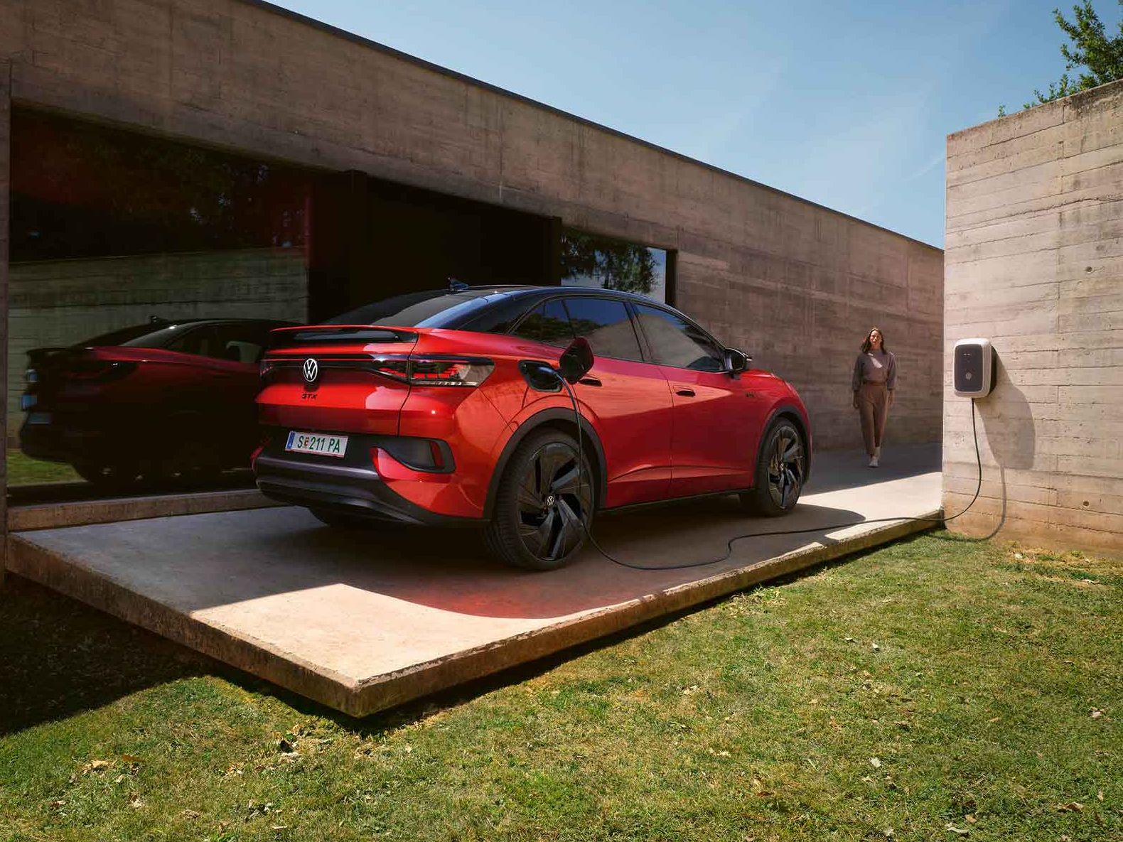 Roter VW ID.5 GTX wird vor Gebäude geladen