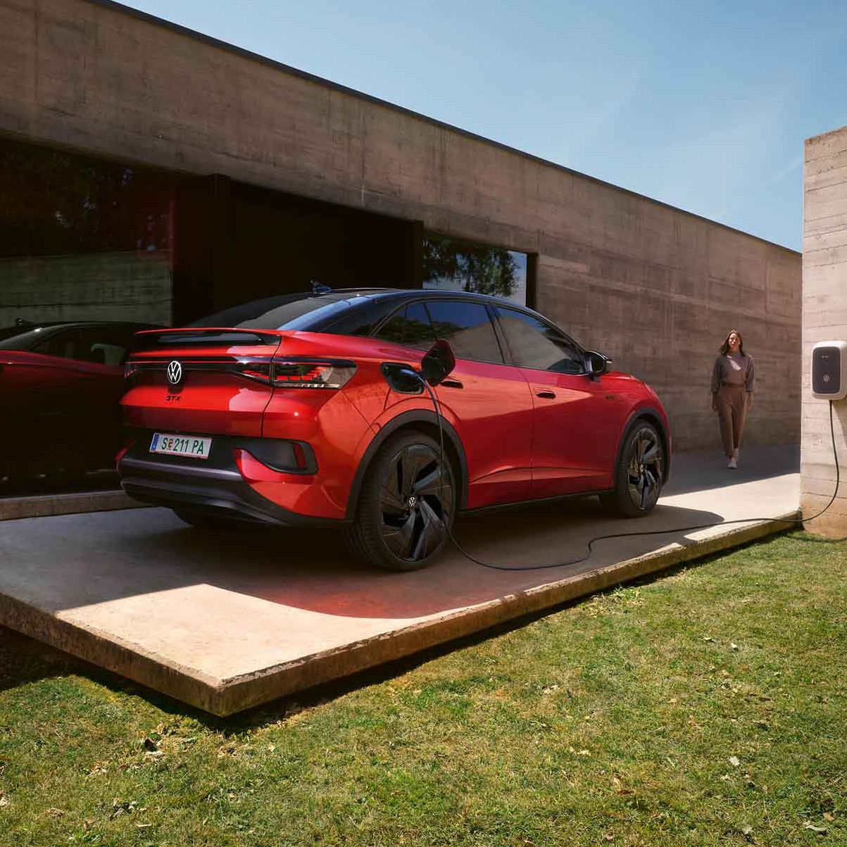 Roter VW ID.5 GTX wird vor Gebäude geladen