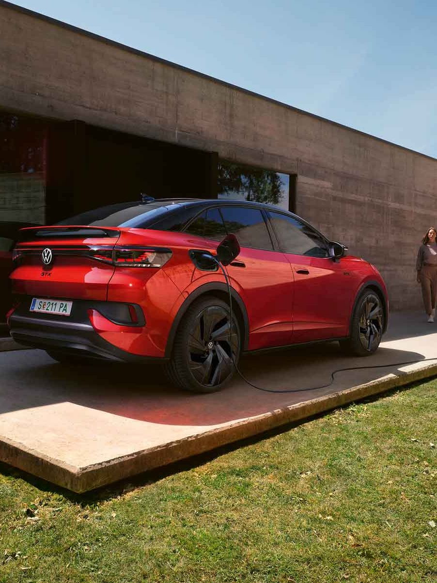 Roter VW ID.5 GTX wird vor Gebäude geladen