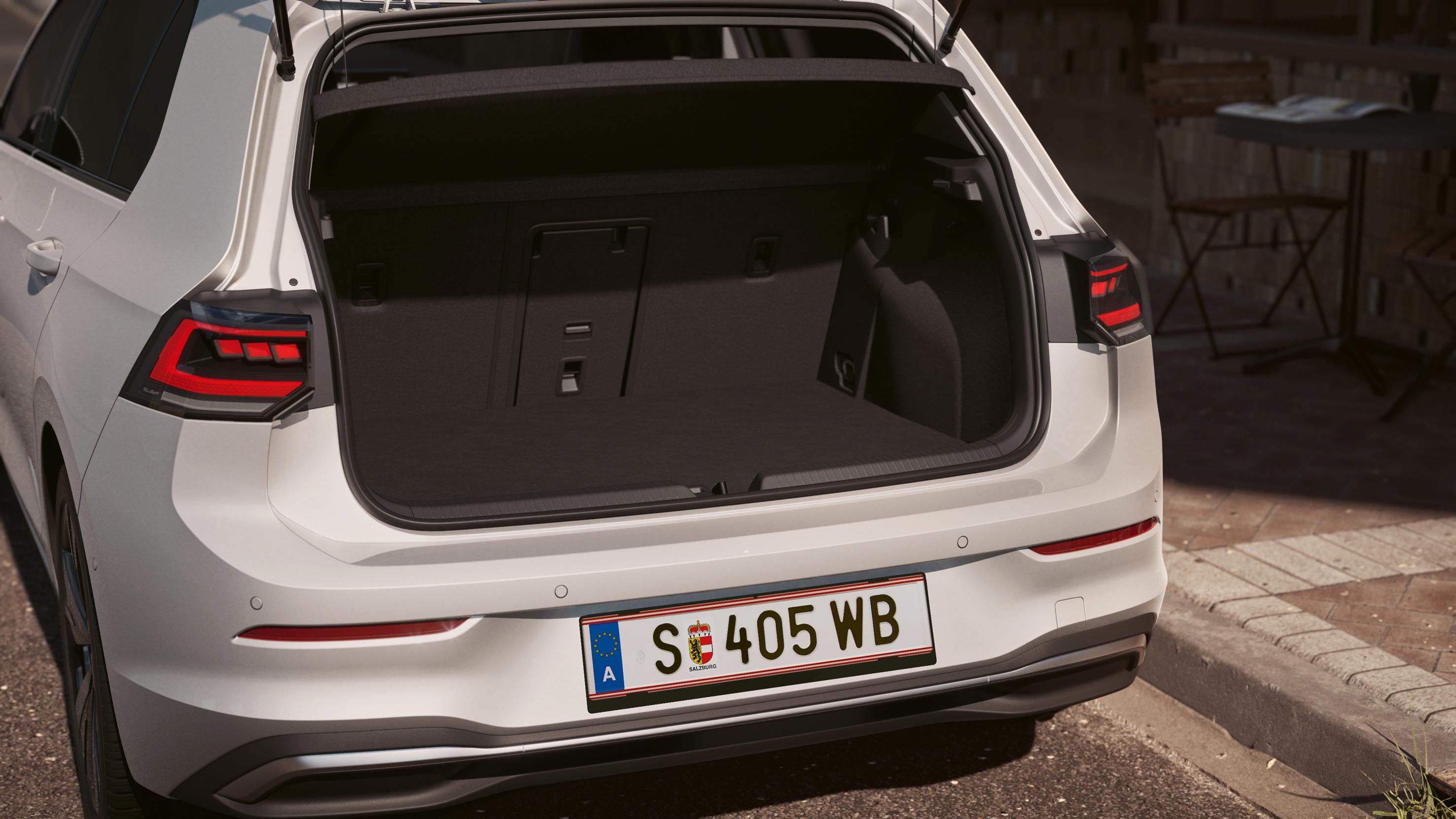 Pogled na zadek belega VW Golfa.