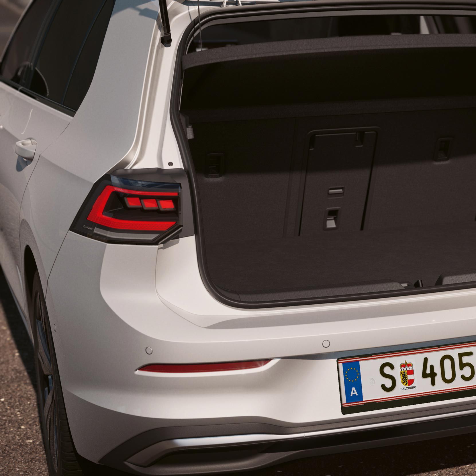 Pogled na zadek belega VW Golfa.