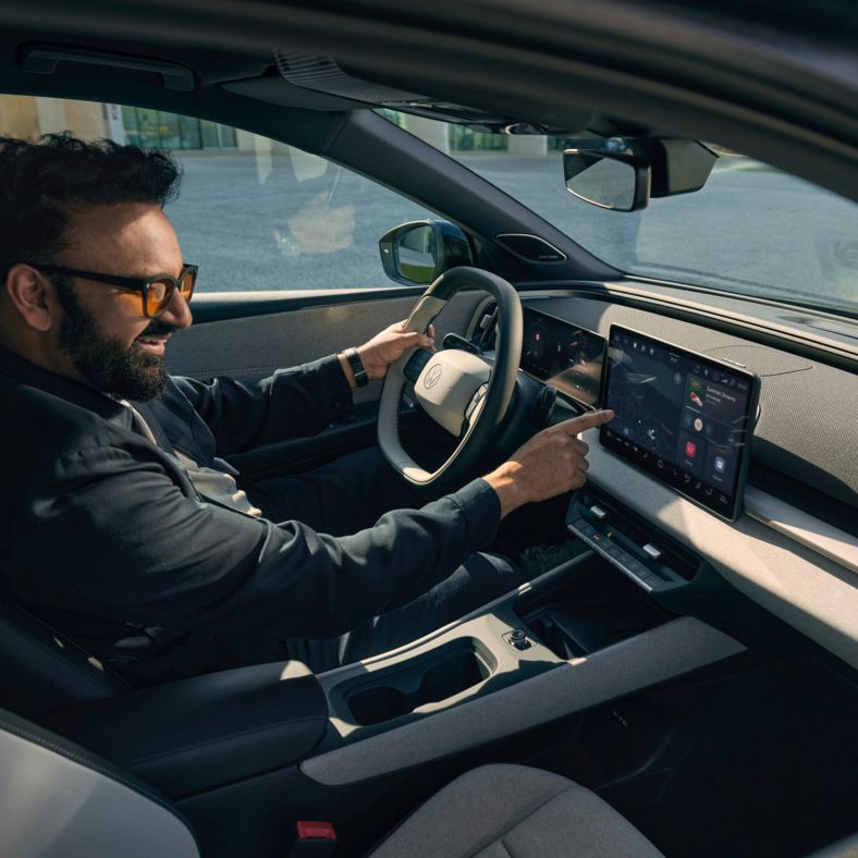 Moški sedi v VW ID. Cross in upravlja infotainment sistem.