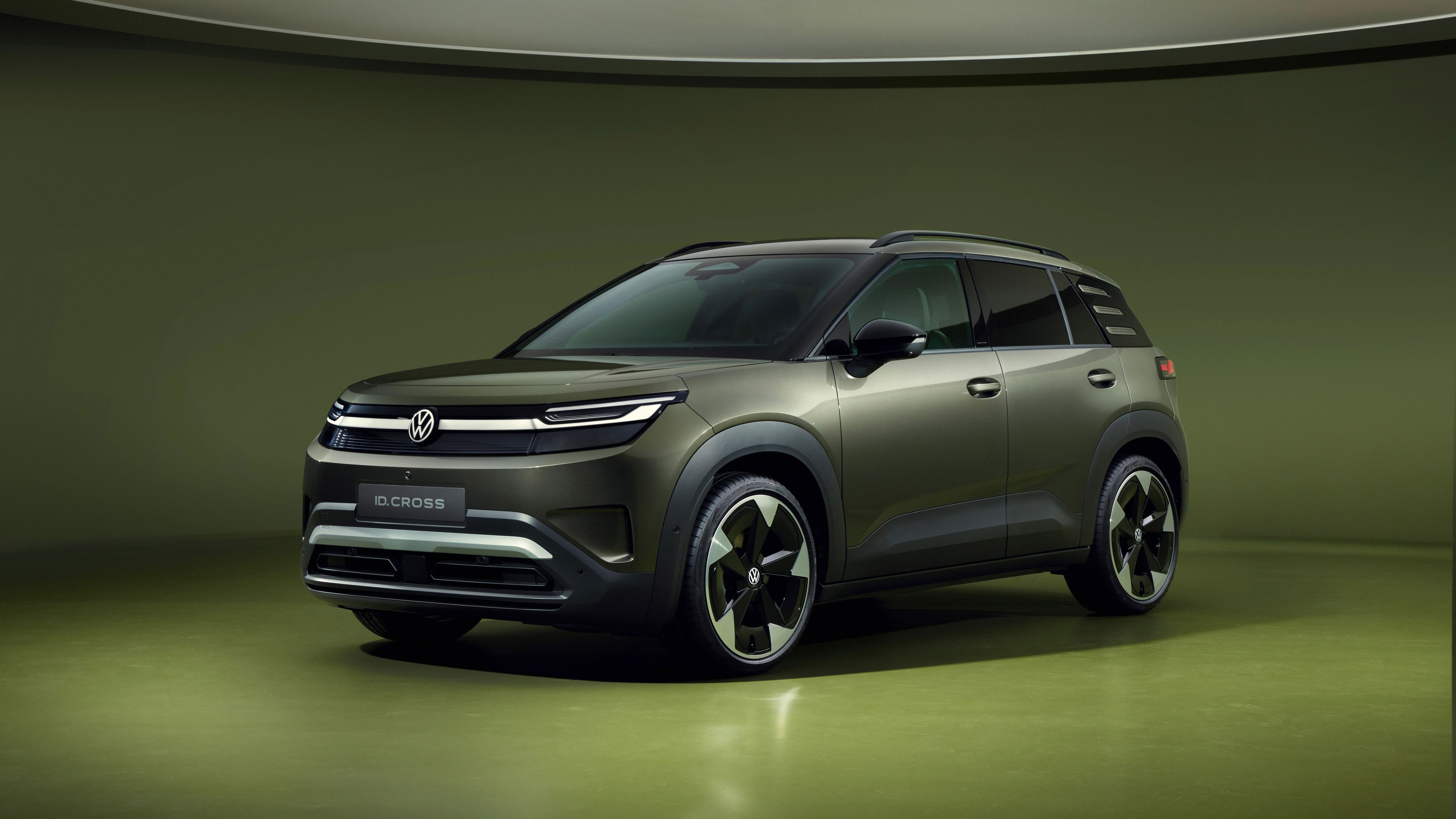 Volkswagen ID. Cross v olivno zeleni barvi, fotografiran s spredaj v studijskem okolju.