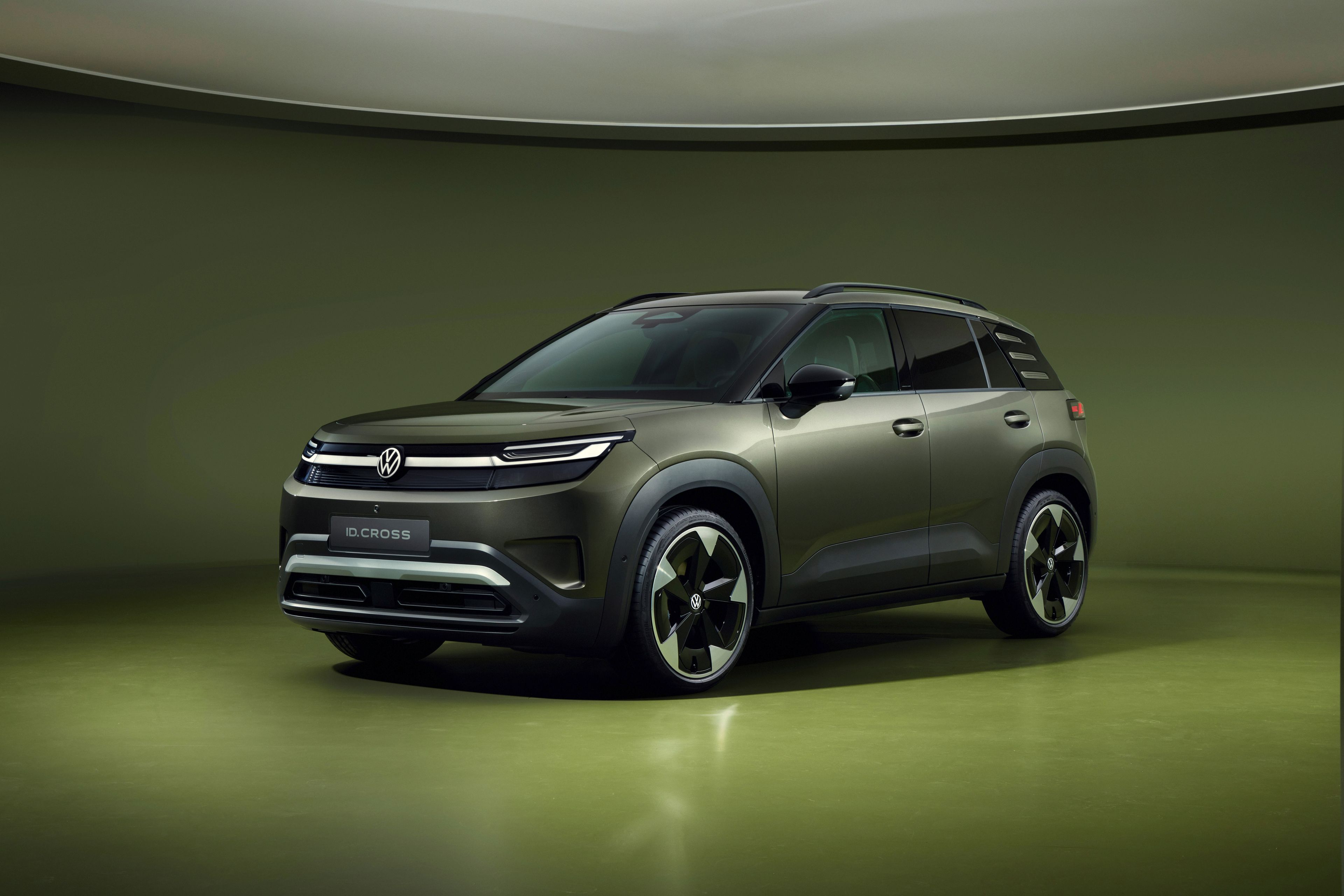 Volkswagen ID. Cross v olivno zeleni barvi, fotografiran s spredaj v studijskem okolju.