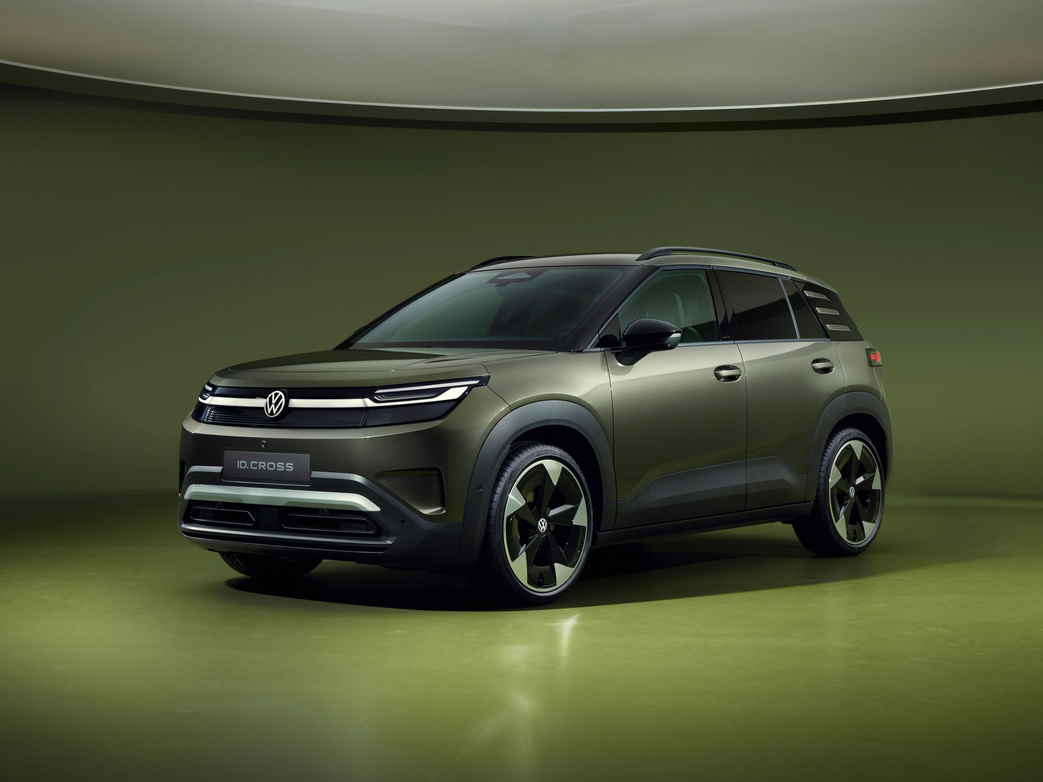 Volkswagen ID. Cross v olivno zeleni barvi, fotografiran s spredaj v studijskem okolju.