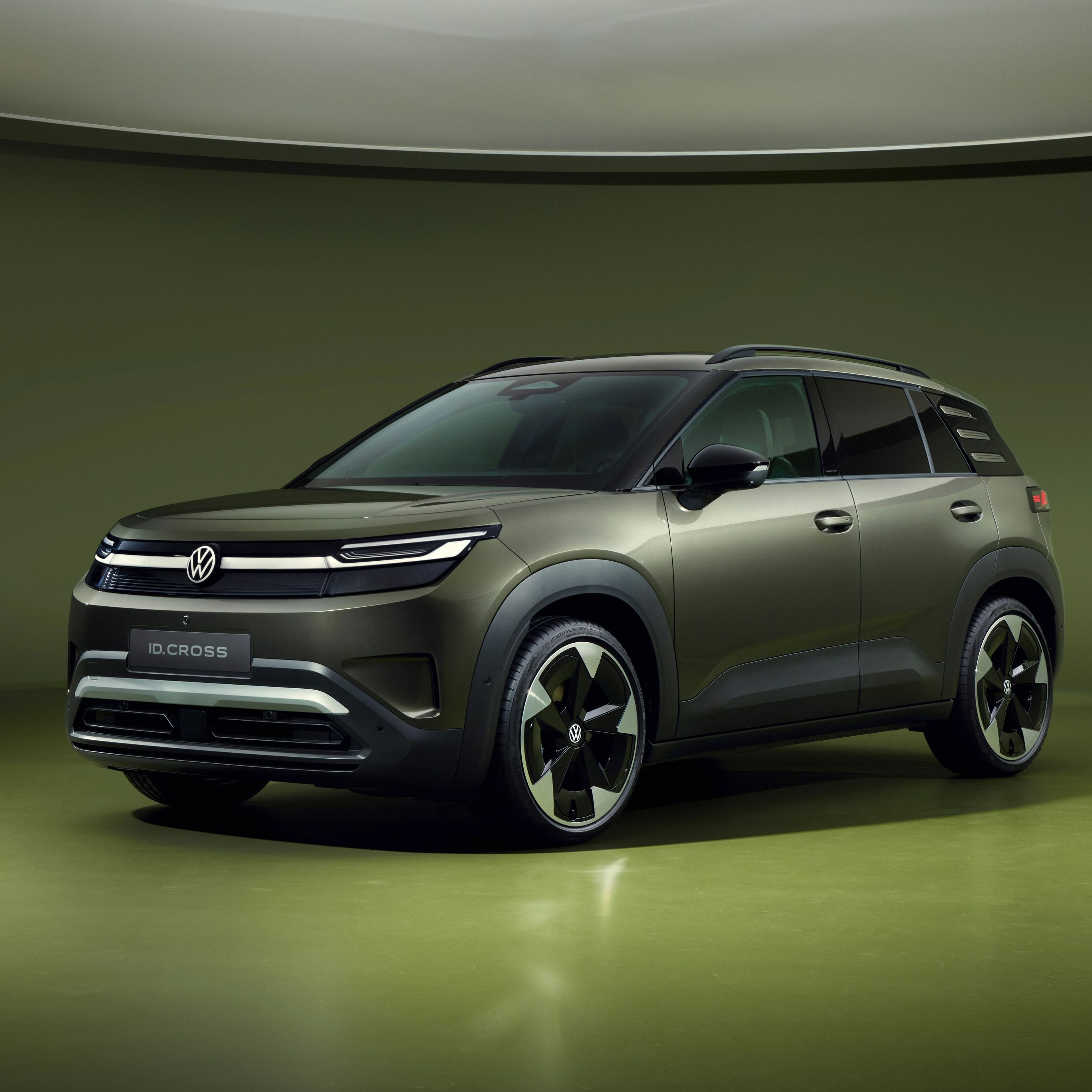 Volkswagen ID. Cross v olivno zeleni barvi, fotografiran s spredaj v studijskem okolju.