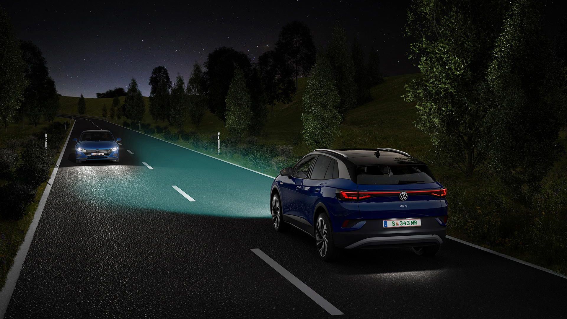 Moder VW ID.4 se z vključenimi lučmi ponoči pelje po cesti.