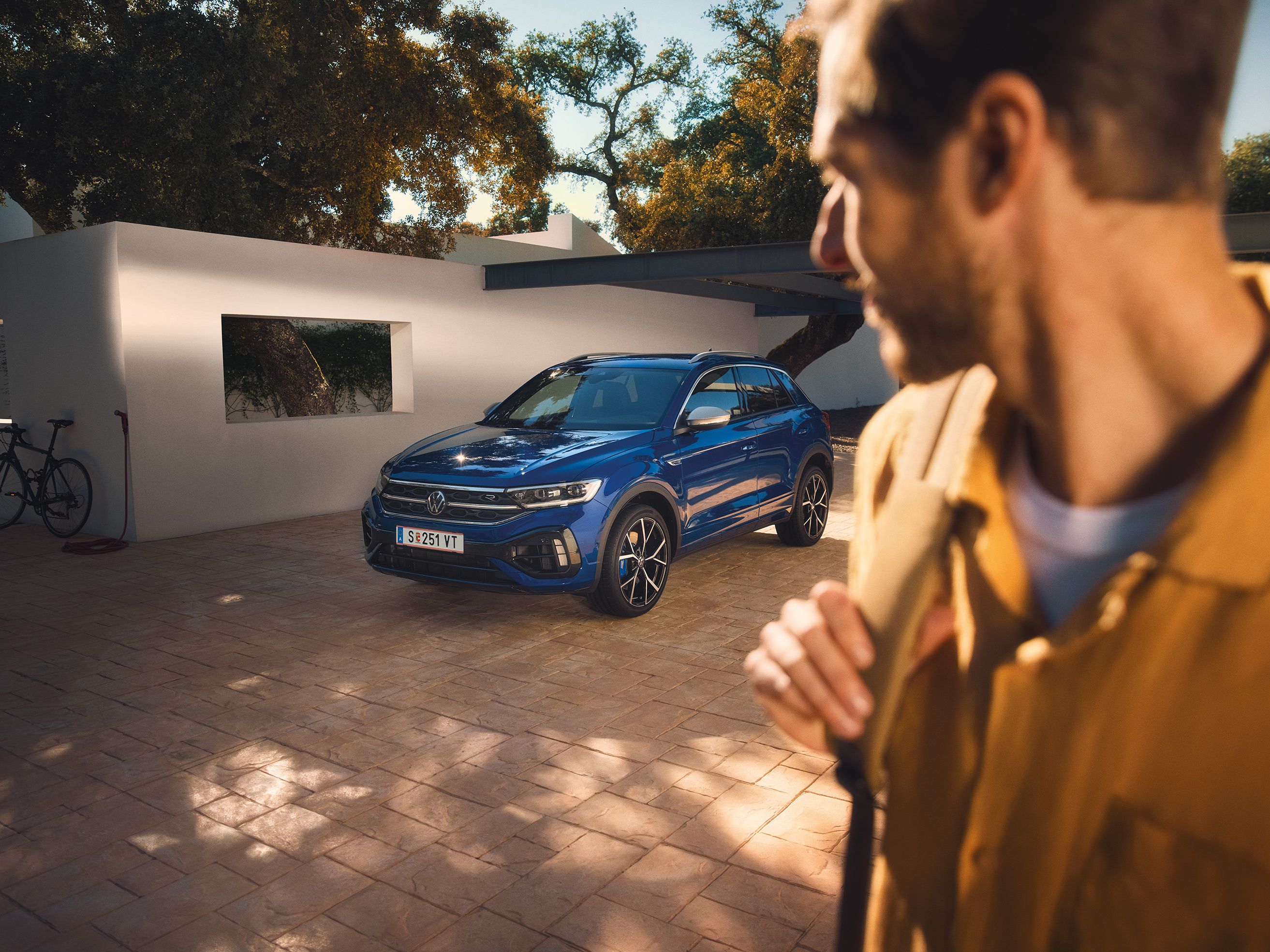 Mann blickt auf lapizblauen VW T-Roc R