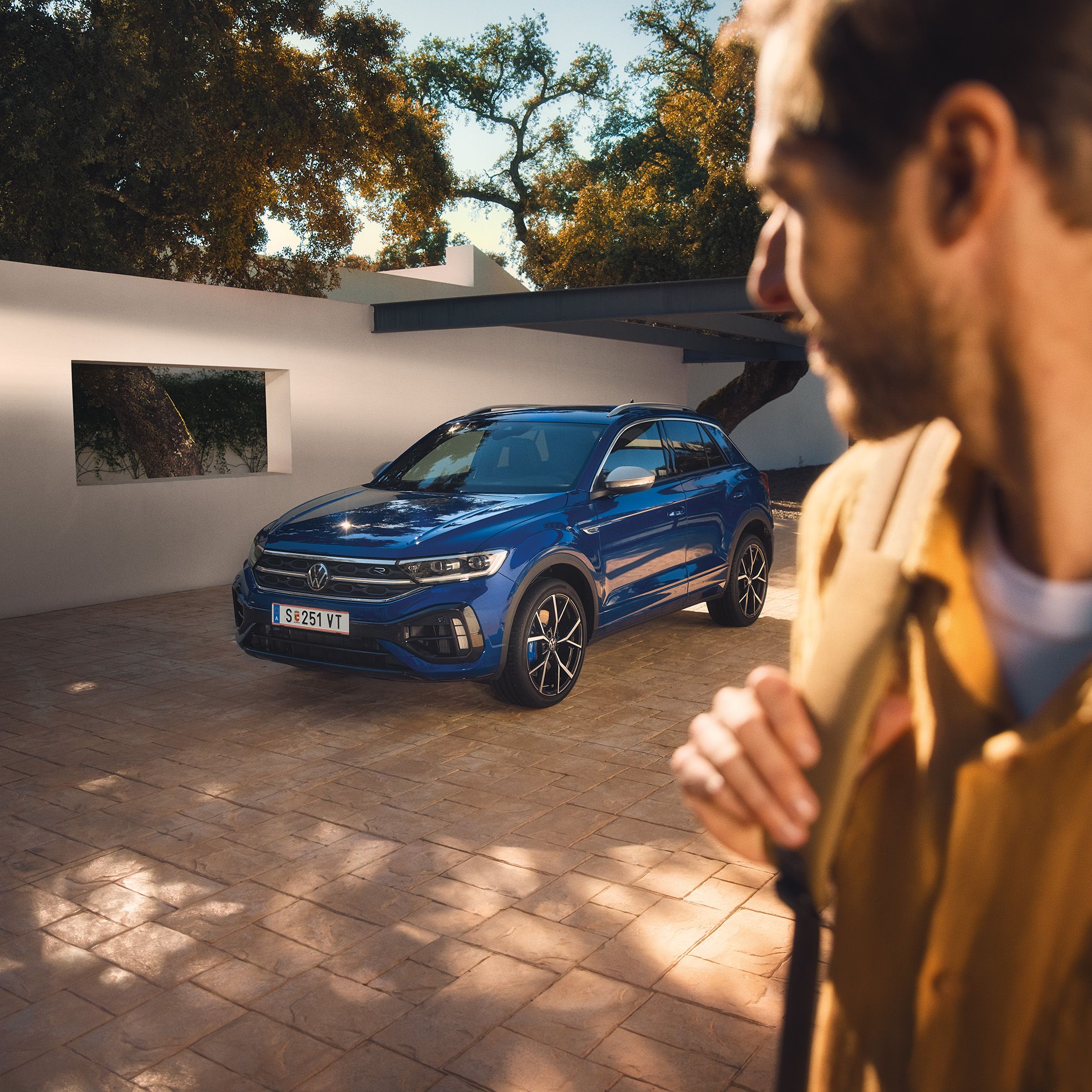 Mann blickt auf lapizblauen VW T-Roc R
