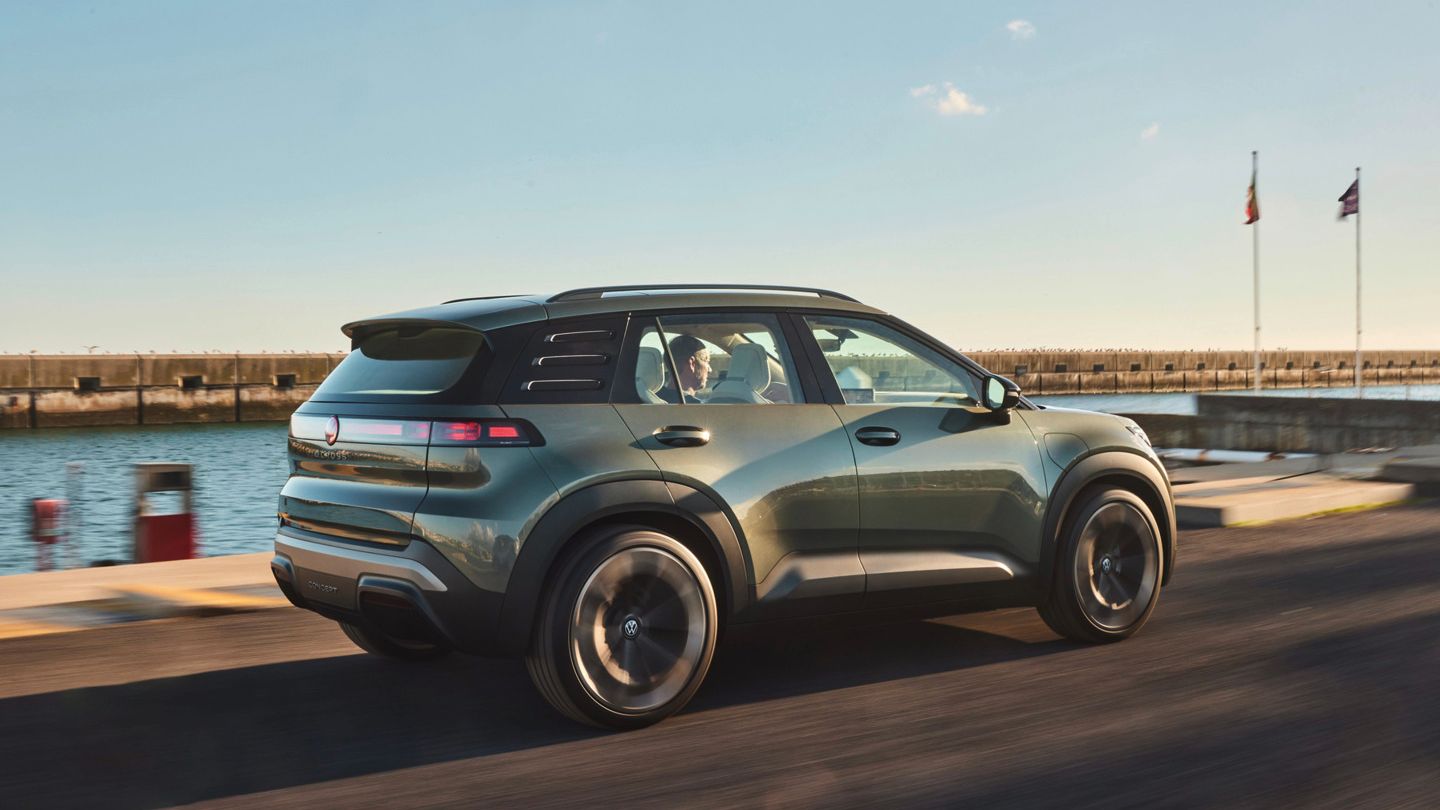 Stranski pogled od zadaj na VW ID. CROSS, ki vozi po obalni cesti.