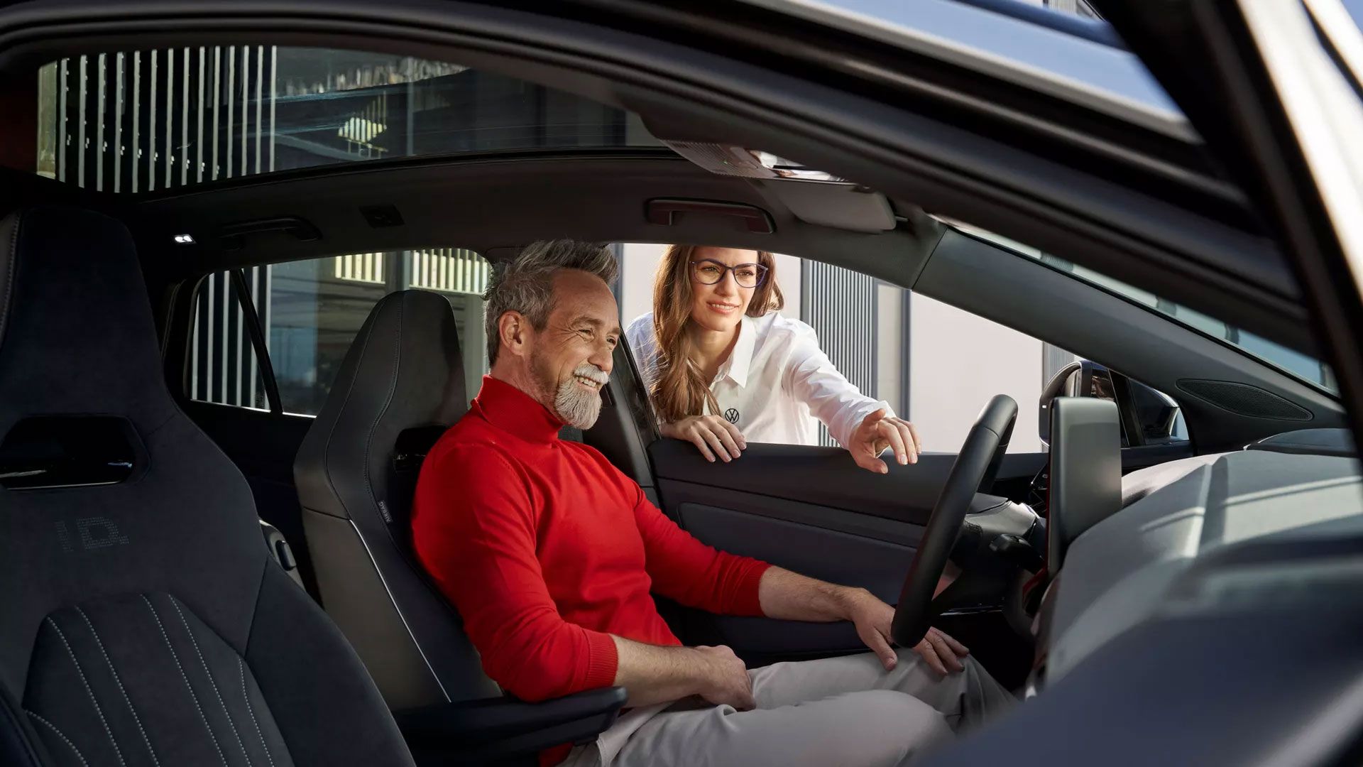 Eine VW Servicemitarbeiterin erklärt einem Kunden die Funktionen des ID.