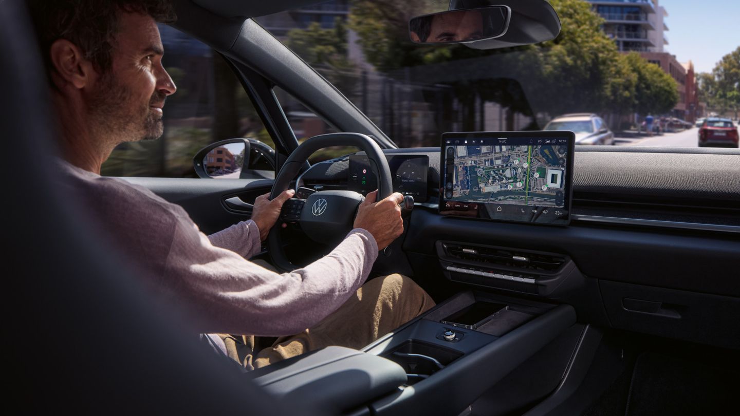 Moški vozi VW ID.3 Neo, ki ga vodi spletna navigacija na osrednjem zaslonu