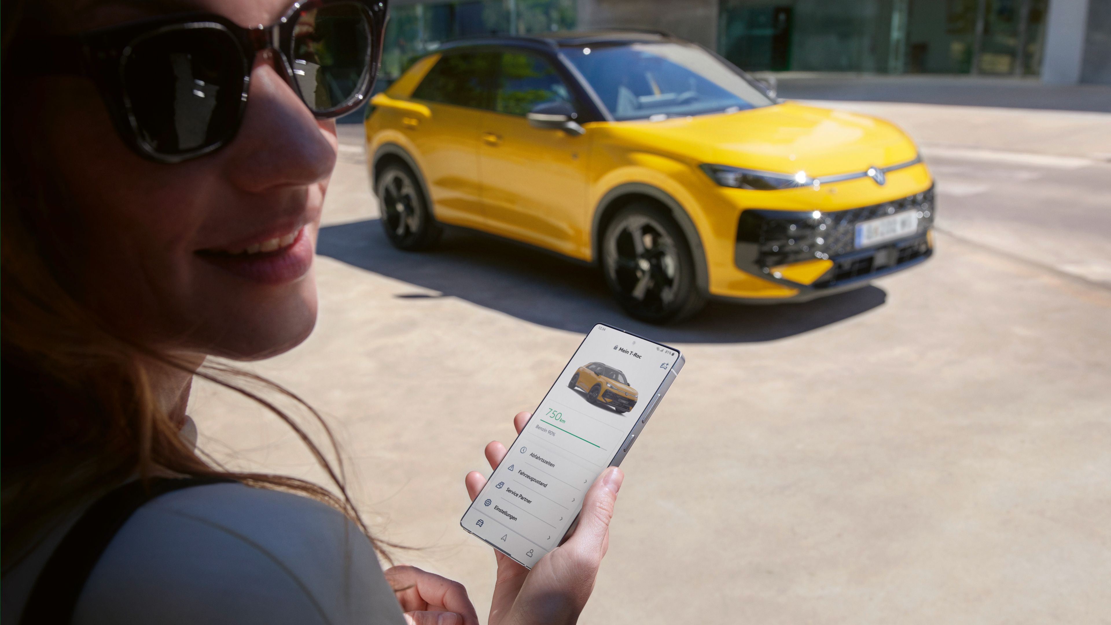 Ženska v bližini svojega vozila VW T-Roc R-Line uporablja aplikacijo VW Connect.