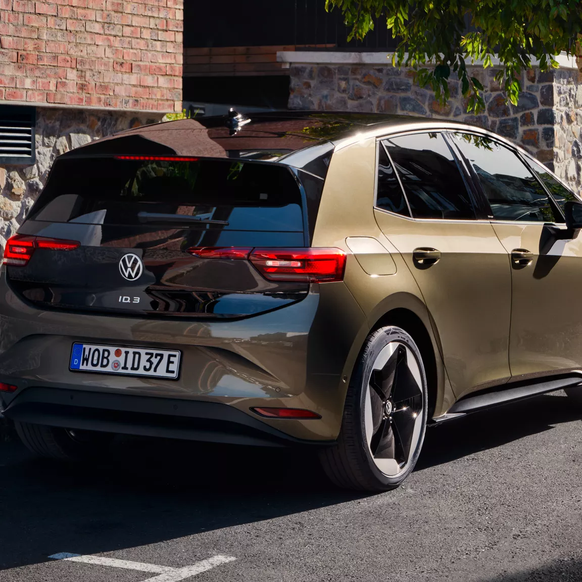 Pogled od zadaj na VW ID.3, ki je bočno parkiran ob robniku. 