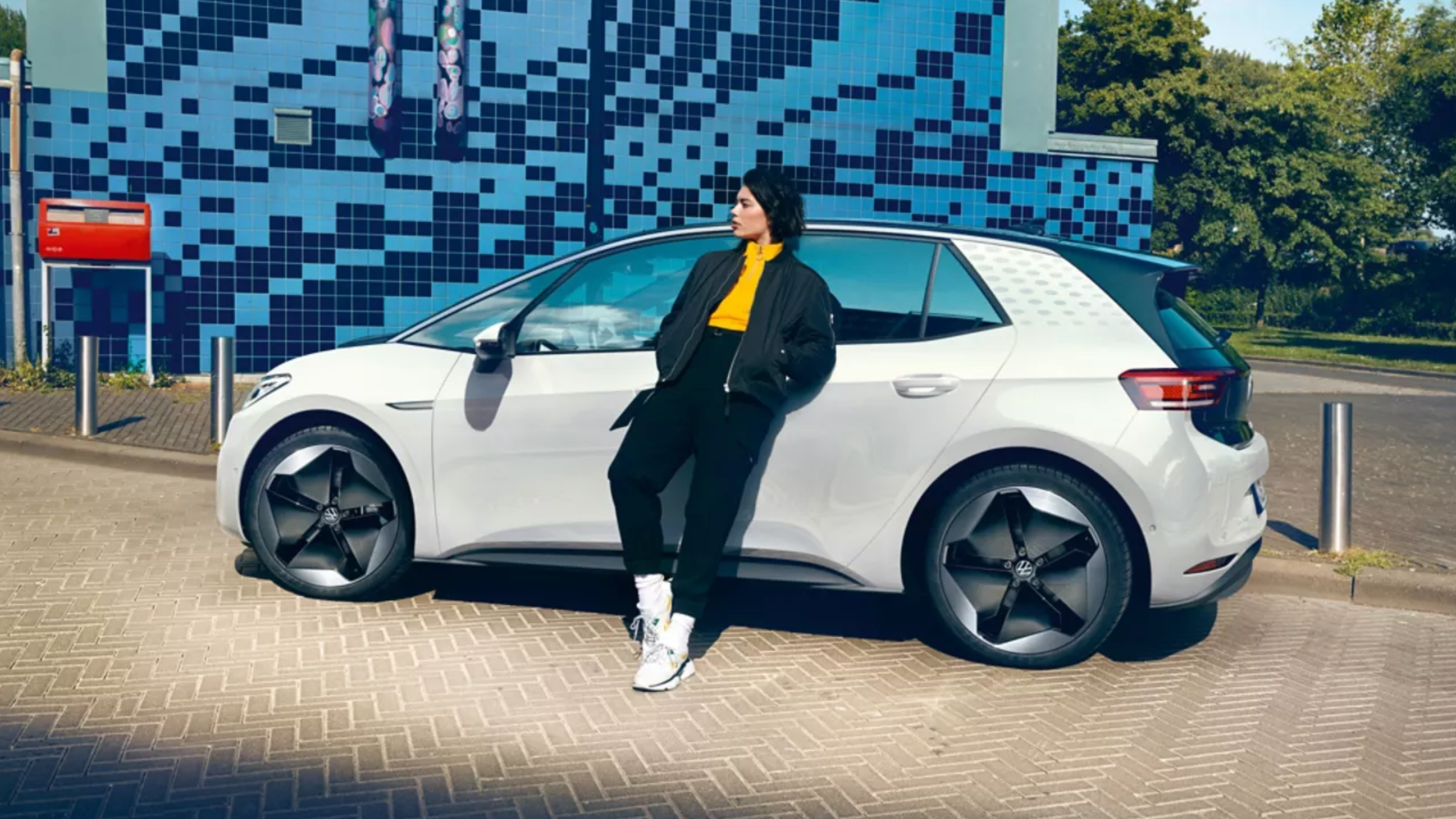 Ženska se naslanja na VW ID.3, parkiran ob robu ceste