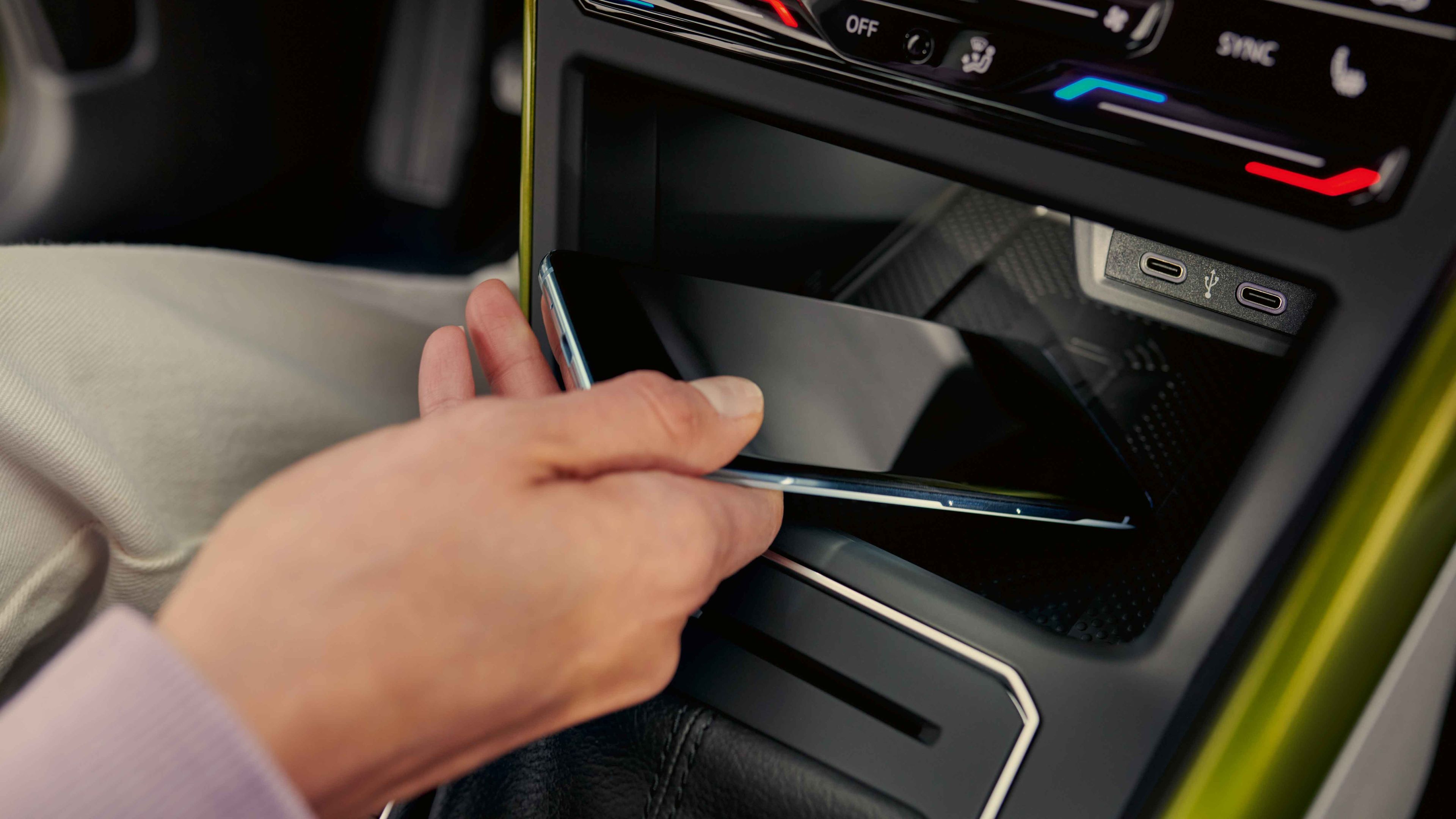 Notranjost modela VW Taigo: ženska odlaga pametni telefon v predal