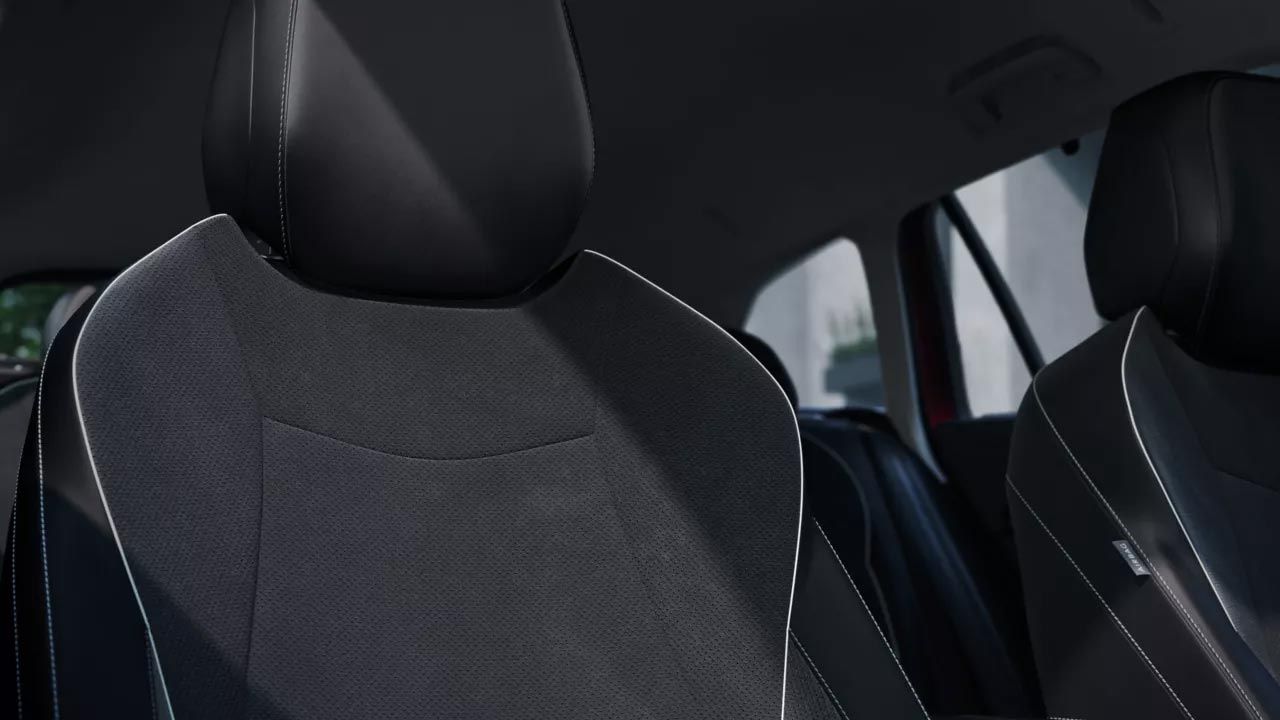 Detajlni posnetek sovoznikovega sedeža v VW Passatu s pogledom v zadnji del vozila.