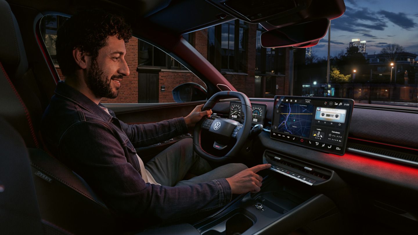 Oseba upravlja gumb na zaslonu sistema v VW ID. Polo GTI.