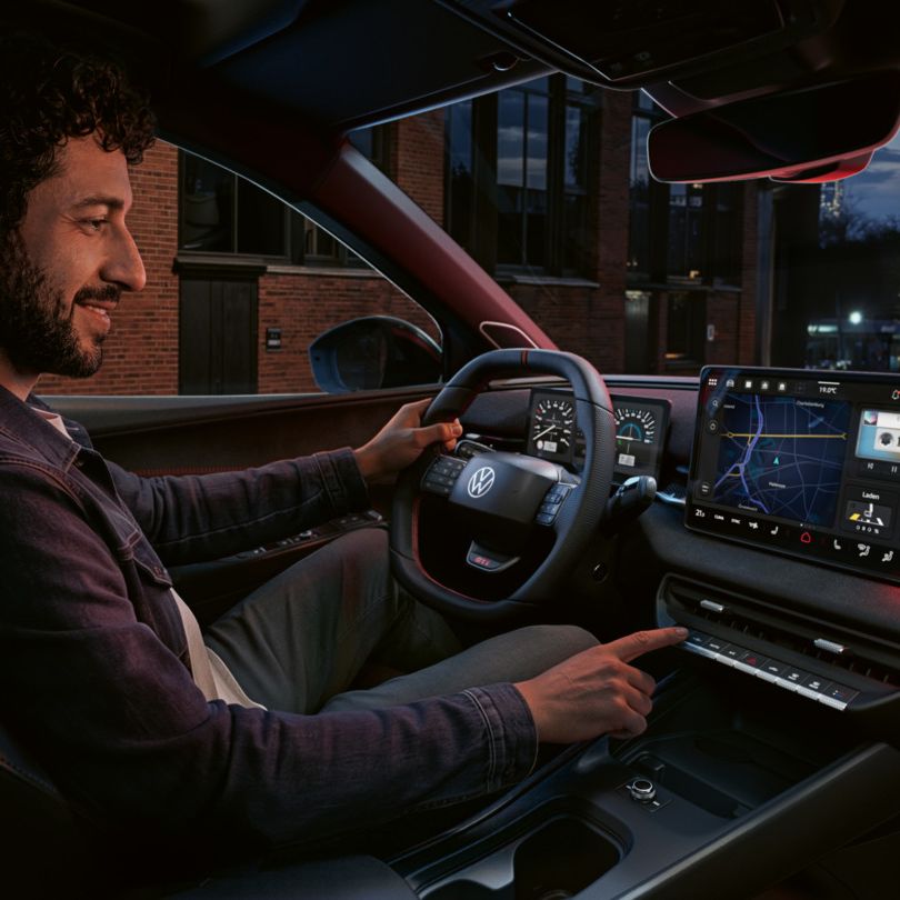 Oseba upravlja gumb na zaslonu sistema v VW ID. Polo GTI.