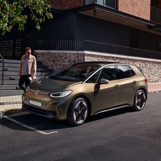 Ein VW ID.3 in olivgrün ist in einer Stadt geparkt, seitliche Ansicht