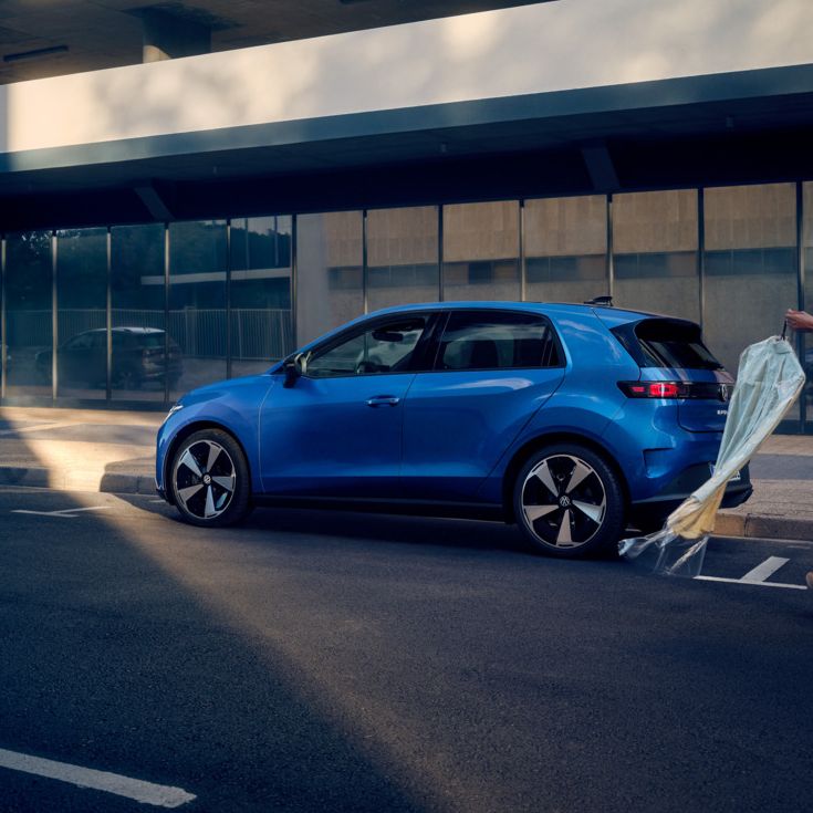 Moder VW ID. Polo Style je parkiran ob cesti, ženska se približa vozilu.