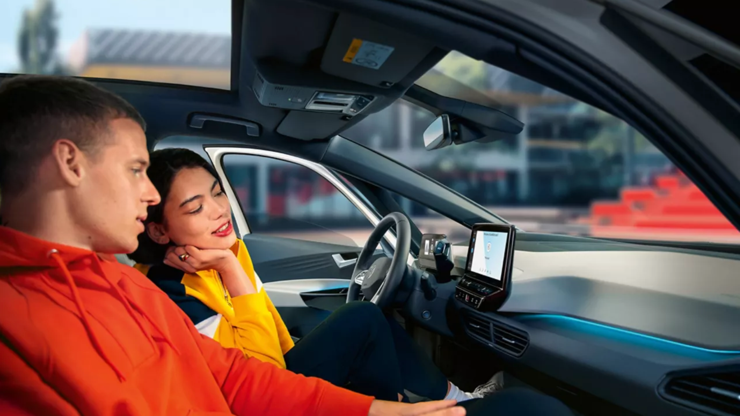 Osebi na sprednjih sedežih modela VW ID.3 si ogledujeta zaslon radia