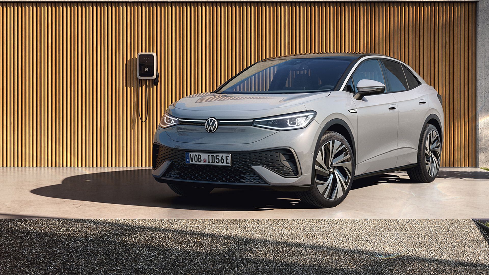 Sivi VW ID.5 je parkiran pred stanovanjsko hišo in se polni s polnilnikom ID Charger.