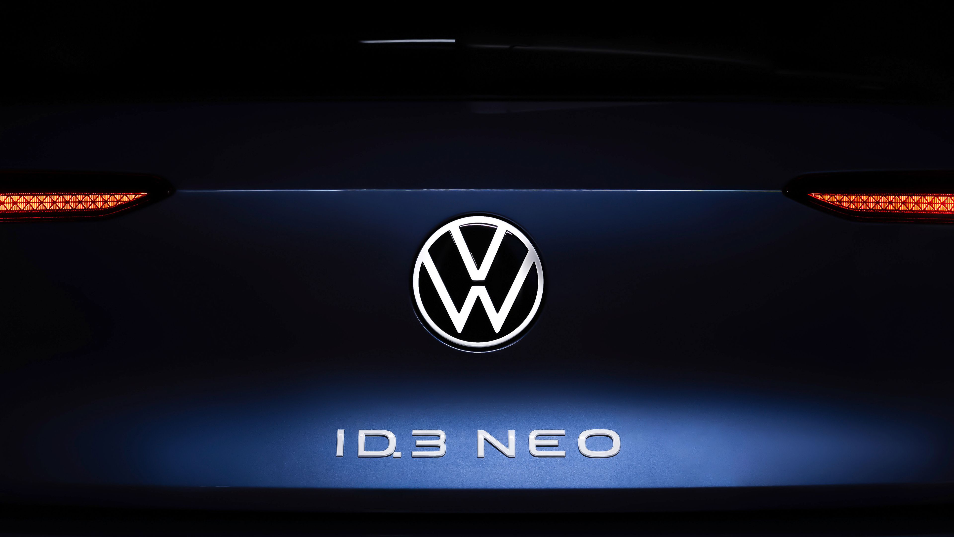 Volkswagen ID.3 Neo koncept v modri barvi. Na prtljažniku napis ID.3 Neo v beli barvi in emblem Volkswagen. Ozadje črno.