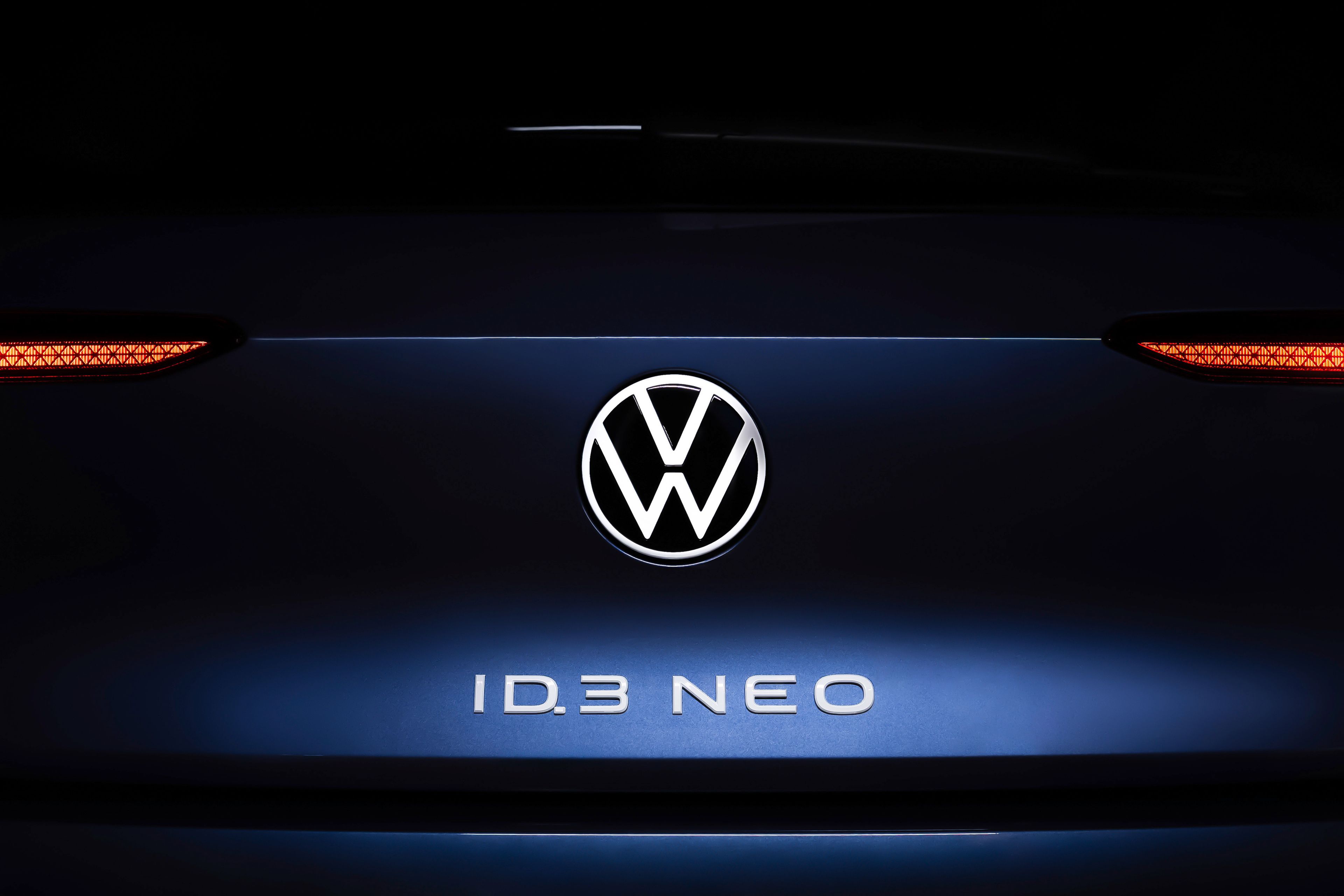 Volkswagen ID.3 Neo koncept v modri barvi. Na prtljažniku napis ID.3 Neo v beli barvi in emblem Volkswagen. Ozadje črno.