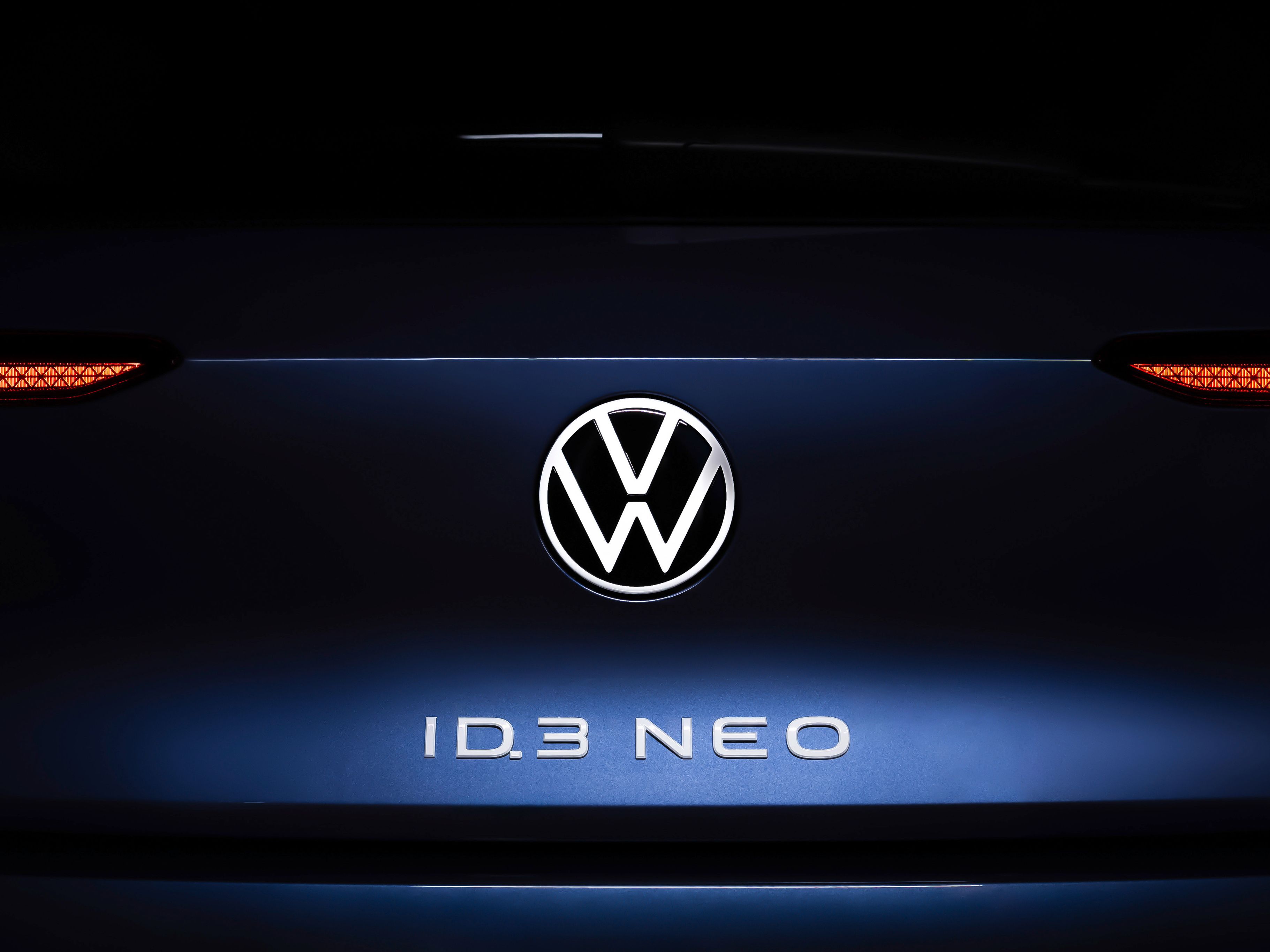 Volkswagen ID.3 Neo koncept v modri barvi. Na prtljažniku napis ID.3 Neo v beli barvi in emblem Volkswagen. Ozadje črno.