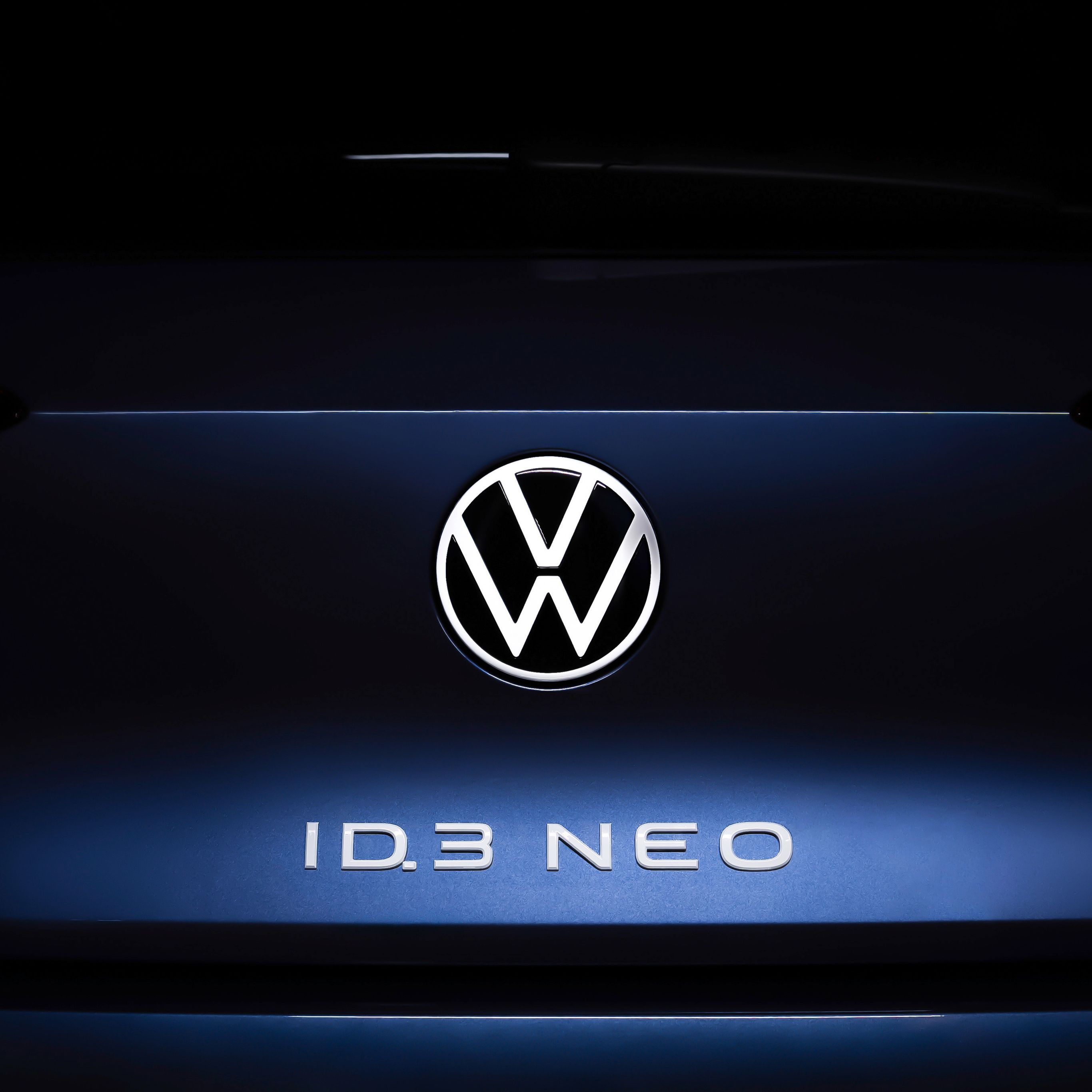 Volkswagen ID.3 Neo koncept v modri barvi. Na prtljažniku napis ID.3 Neo v beli barvi in emblem Volkswagen. Ozadje črno.